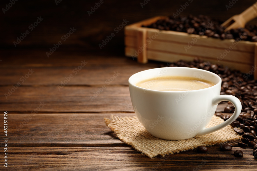 Coffee cup and coffee beans on a wooden background. Coffee cup and coffee beans on a wooden background.