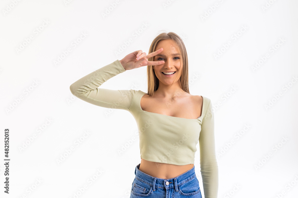 Happy young woman showing peace sign with both hands over white background Happy young woman showing peace sign with both hands over white background