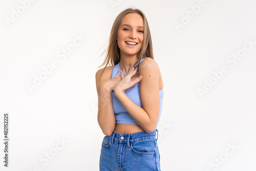 Attractive modern woman with bun, smiling broadly at camera and expressing positive emotions wjile standing over white background. photo