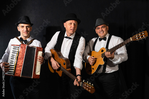 Fotografie Trio of musicians on a black background