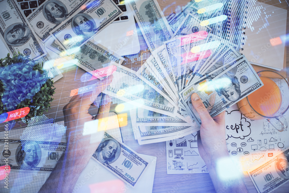 Multi exposure of technology drawing hologram and us dollars bills and man hands. Data concept Multi exposure of technology drawing hologram and us dollars bills and man hands. Data concept