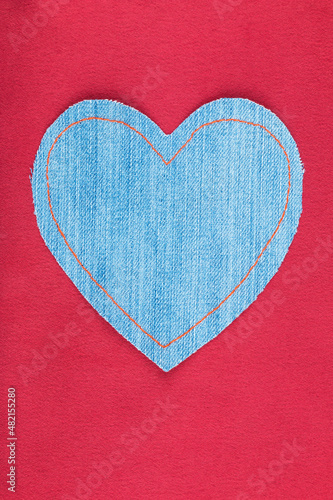 Empty heart with space for design  space for text. Heart symbol lying on red silk.