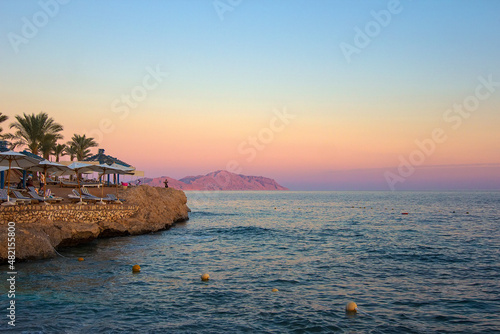 Sunset at luxury tropical resort on Red Sea coast in Sharm el Sheikh, popular resort in Egypt, Africa. Dusk over Sharks Bay. Tourism and travel. Rest and vacation.