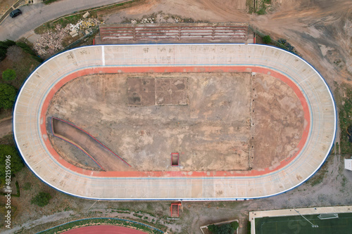 Horizontal top view of a abandoned velodrome next to a running track in Burriana, Spain