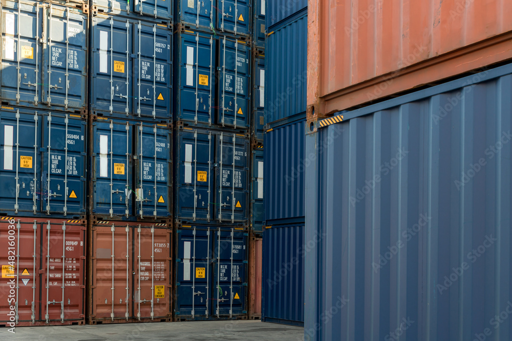 Fototapeta premium Stack of containers in a harbor. Shipping containers stacked on cargo ship. Background of Stack of Containers at a Port.