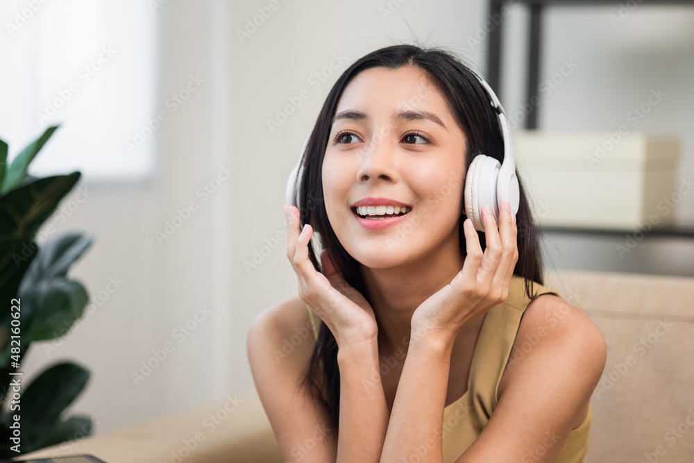 Relaxing time with music. Beautiful young asian woman sitting in the house choose music and take a rest and listening song with wireless headphone. Lifestyle in living room at house in the morning. Relaxing time with music. Beautiful young asian woman sitting in the house choose music and take a rest and listening song with wireless headphone. Lifestyle in living room at house in the morning.
