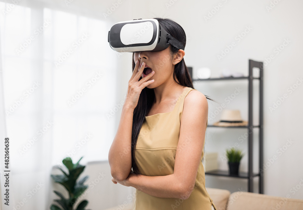 Young asian woman put on vr glasses into virtual simulated world. Future technology digital cyber universe. Person Enjoying an Experiences of Virtual World. Young asian woman put on vr glasses into virtual simulated world. Future technology digital cyber universe. Person Enjoying an Experiences of Virtual World.