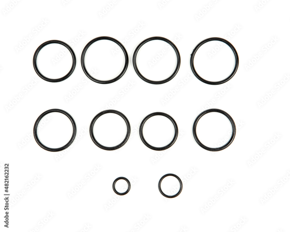 Hydraulic and pneumatic o-rings in black in different sizes on a white background. Various seals for plumbing. Sealing rings for hydraulic connections. Hydraulic and pneumatic o-rings in black in different sizes on a white background. Various seals for plumbing. Sealing rings for hydraulic connections.