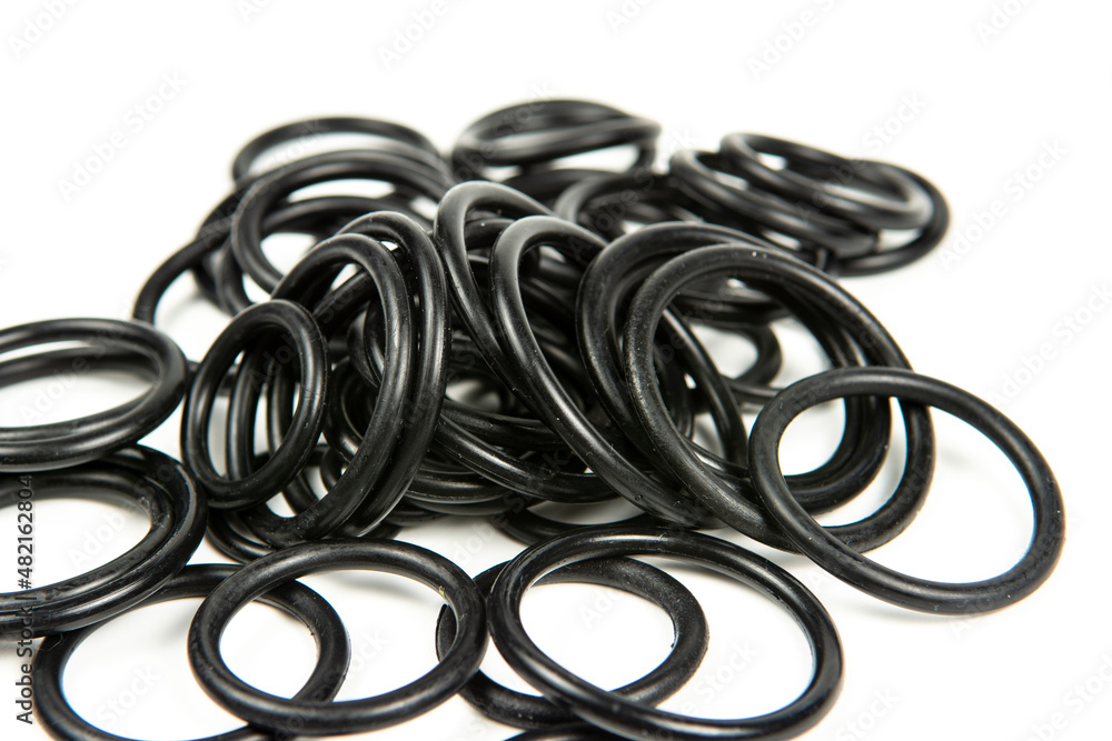 Hydraulic and pneumatic o-rings in black in different sizes on a white background. Various seals for plumbing. Sealing rings for hydraulic connections. Hydraulic and pneumatic o-rings in black in different sizes on a white background. Various seals for plumbing. Sealing rings for hydraulic connections.