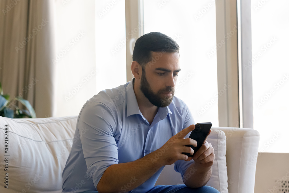 Focused millennial mobile phone user man chatting online, reading text message, surfing social media, Internet, using online app for communication. Businessman checking messenger, email on smartphone Focused millennial mobile phone user man chatting online, reading text message, surfing social media, Internet, using online app for communication. Businessman checking messenger, email on smartphone