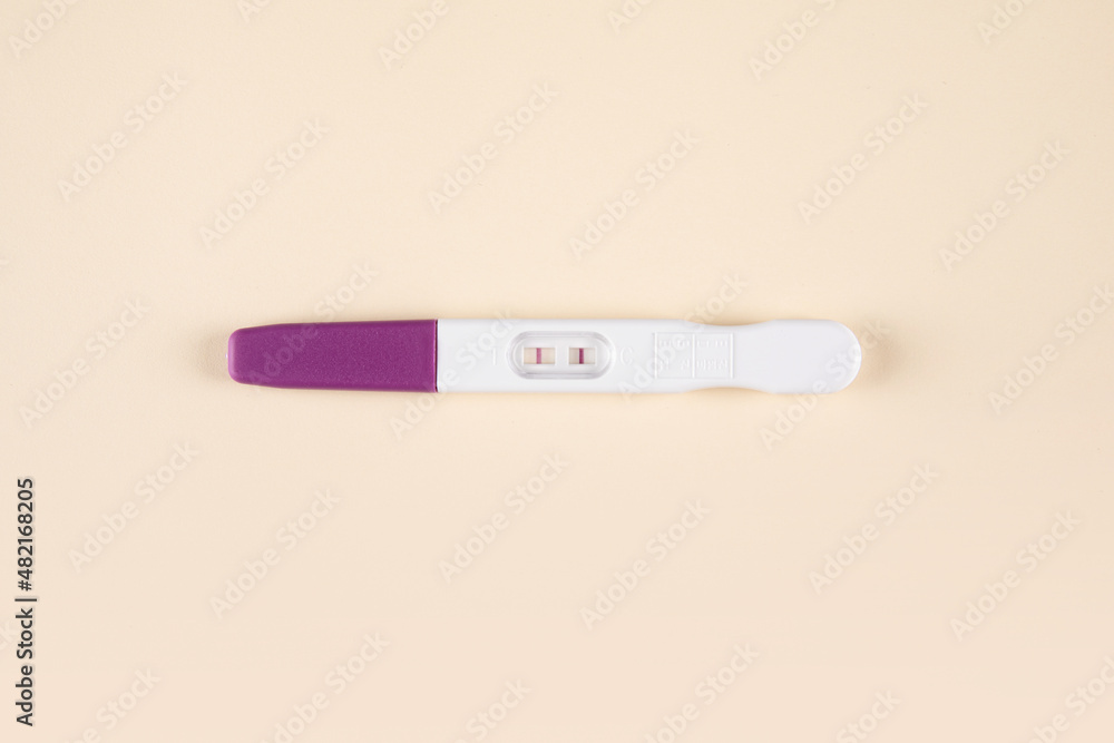 Pregnancy test kit with positive results isolated on paper background Pregnancy test kit with positive results isolated on paper background