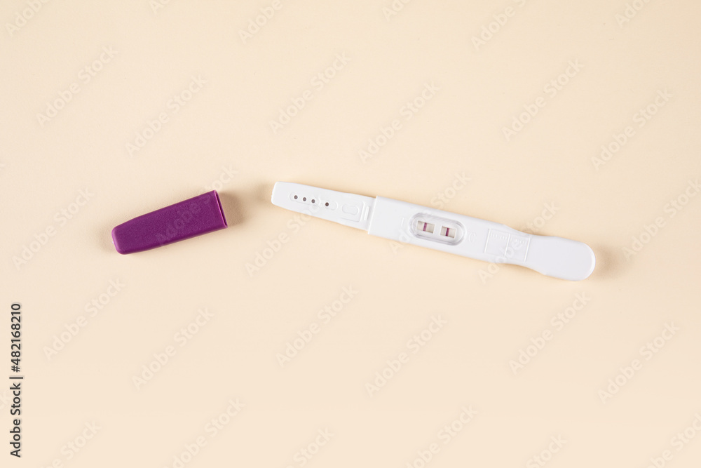 Pregnancy test kit with positive results isolated on paper background Pregnancy test kit with positive results isolated on paper background