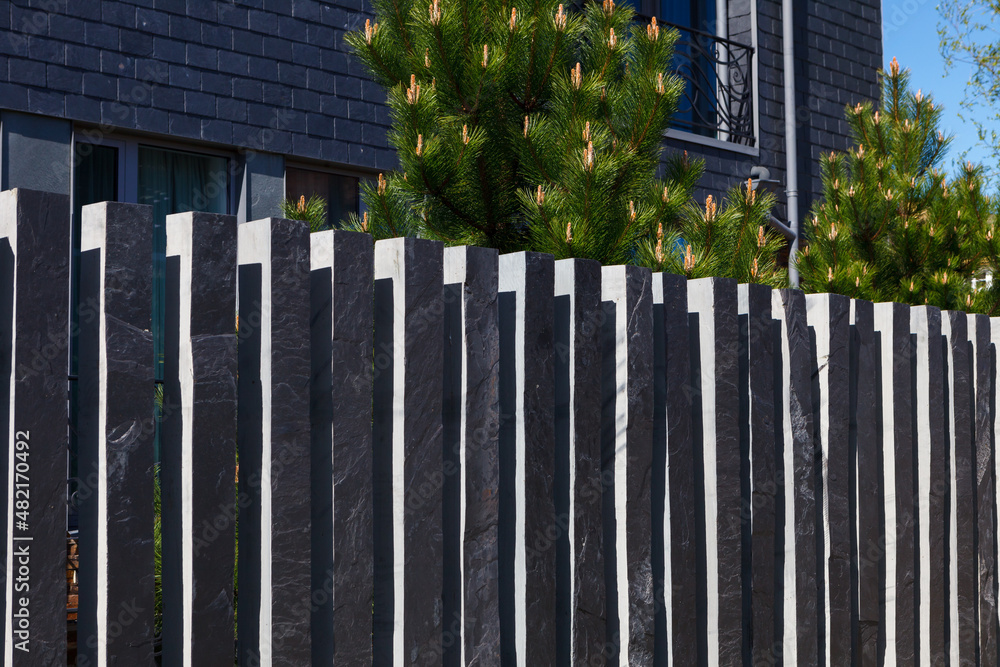 Modern fence made of bars (pillars) of gray, mountain, Silesian slate. Modern fence made of bars (pillars) of gray, mountain, Silesian slate.