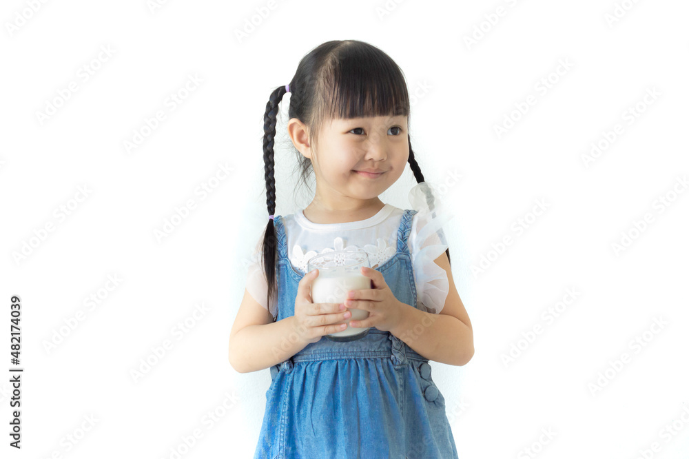 Portrait cute smiling Asian girl holding a glass of milk with white background..