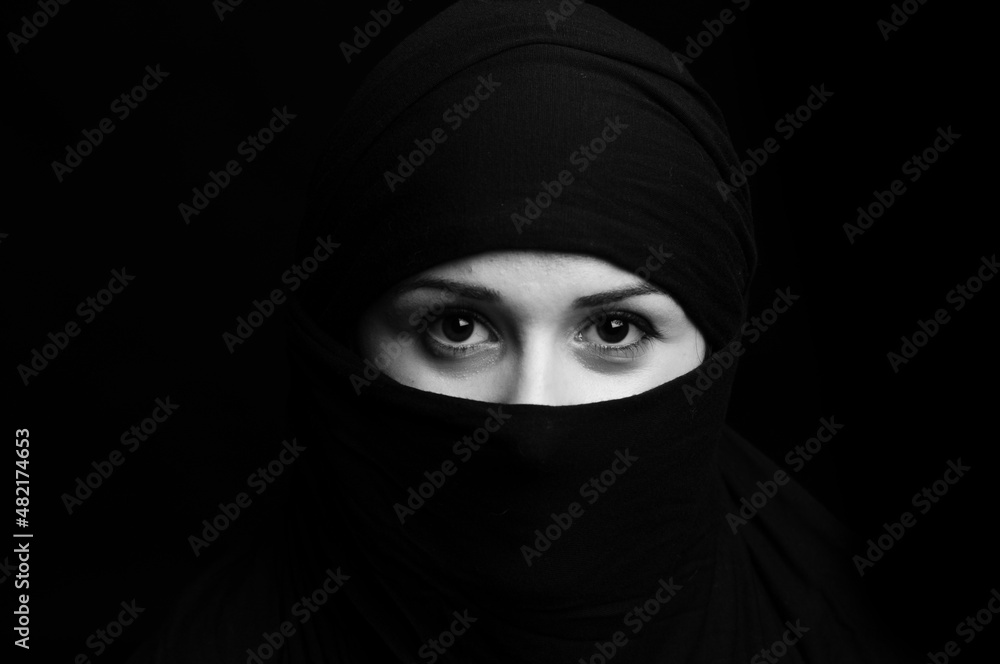 beautiful oriental girl in a black veil on a black background

