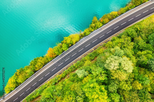 The road near turquoise lake. Aerial landscape. The road by the lake in Switz...