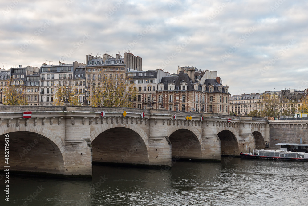 Fototapeta premium Pont Neuf crossing the Seine River to some vintage buildings