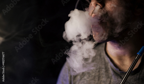 Man smoker, exhales smoke