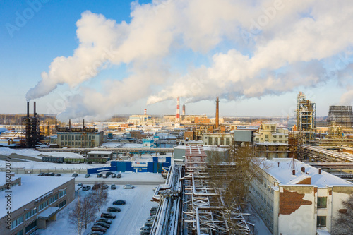 Industrial landscape. Panoramic view of the technological pipe and industrial infrastructure. Chemical production with red-white pipes and smoke is coming. Production buildings.