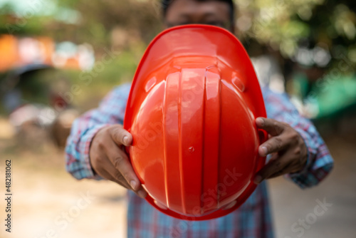 man holding an orange hat