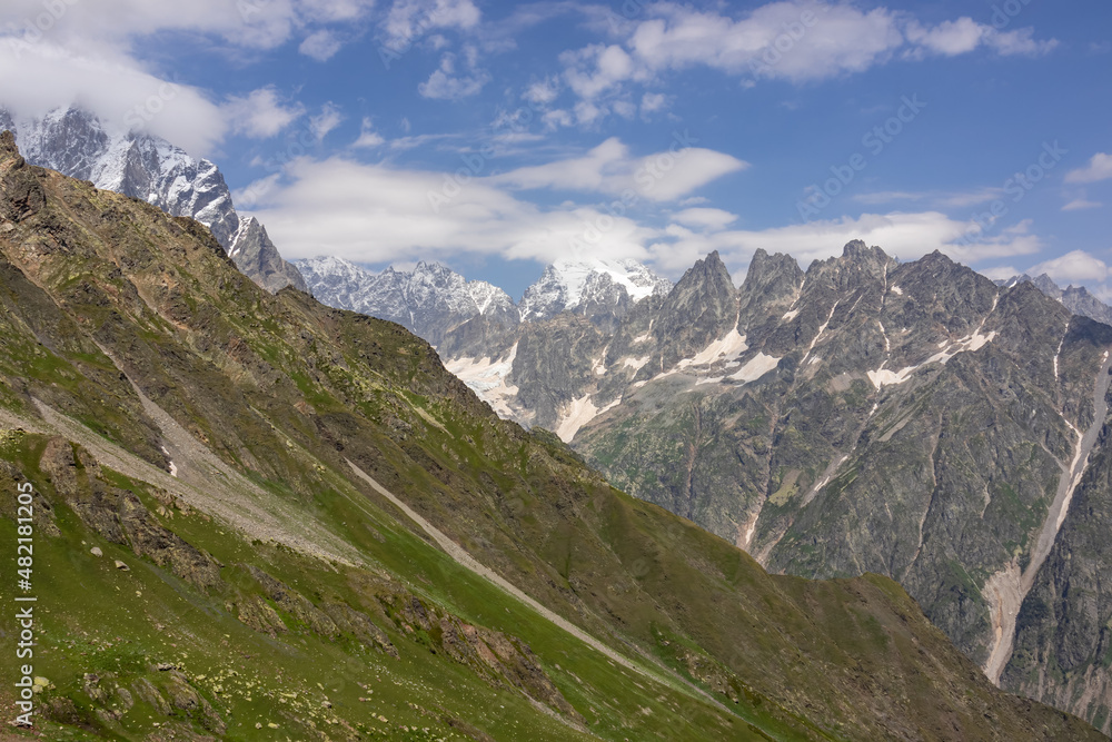 An amazing panoramic view on the mountain ridges near Mestia in the Greater Caucasus Mountain Range, Samegrelo-Upper Svaneti, Country of Georgia. The sharp peaks are covered in snow. Wanderlust