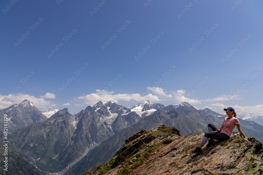 A female hiker enjoying the amazing views on the mountain ridges in the Greater Caucasus Mountain Range in Georgia, Samegrelo-Upper Svaneti Region. Freedom. Wanderlust. Trekking to Koruldi Lakes