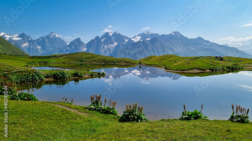 A horse grazing at the Koruldi Lake with a dream like view on the mountain range near Mestia in the Greater Caucasus Mountain Range, Upper Svaneti, Country of Georgia. Wildlife observation.