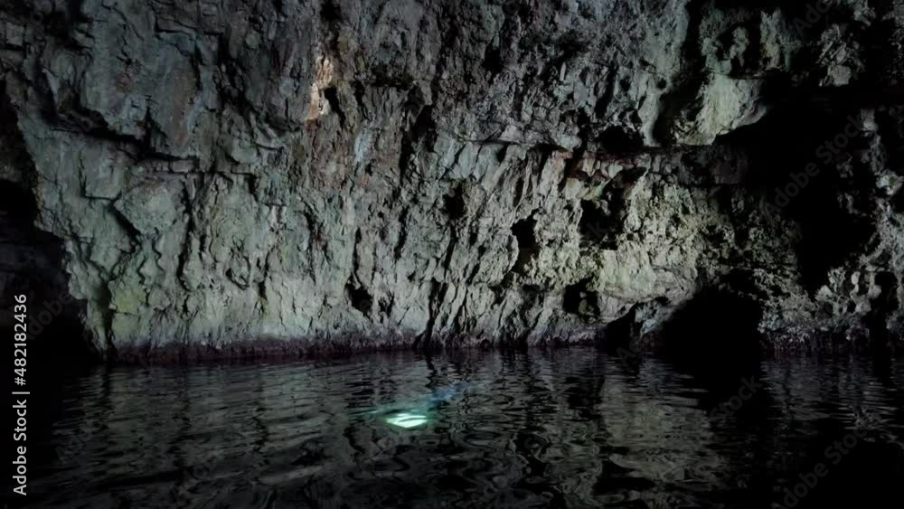 Mysterious scene inside a sea cave with a ray of light coming down from the ceiling and reflecting on a wall, Vis island, Adriatic Sea, Croatia Mysterious scene inside a sea cave with a ray of light coming down from the ceiling and reflecting on a wall, Vis island, Adriatic Sea, Croatia