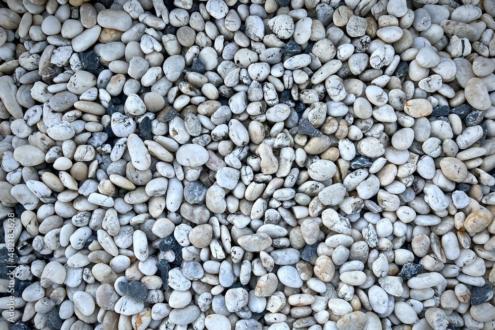 Smooth round pebbles texture background. Pebble sea beach close-up, dark wet pebble and gray dry pebble. Smooth round pebbles texture background. Pebble sea beach close-up, dark wet pebble and gray dry pebble.