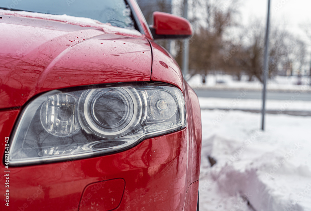 Red car headlight close up photo in winter