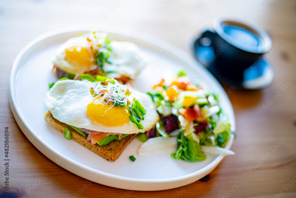 Breakfast with fried eggs on toasts on a restaurant table Breakfast with fried eggs on toasts on a restaurant table