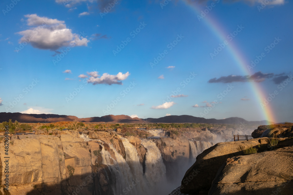Rainbow created in the mist over the Augrabies falls with the Orange river in flood during January 2022