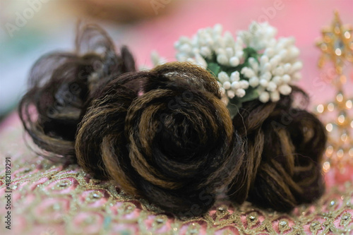black rose shaped hair accessory on a pink delicate fabric © jayanthi photography