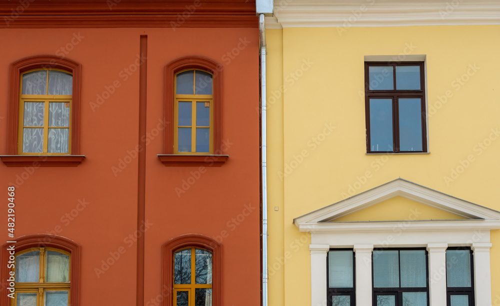 red and yellow building with windows next to each other, geometric composition of two buildings