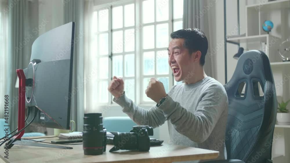 Asian Cameraman In Long Sleeved T-Shirt Looking At Desktop Computer Screen And Being Happy Due To Success While Using Desktop Computer For Working At Home.
Asian Cameraman In Long Sleeved T-Shirt Looking At Desktop Computer Screen And Being Happy Due To Success While Using Desktop Computer For Working At Home.