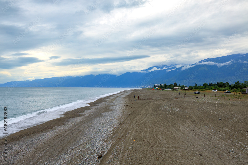 sea coast with waves ashore, cloudy weather, out of season