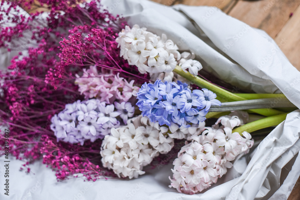 Blumenstrauß mit Hyazinthen und Schleierkraut in Papier verpackt, Blumen im Frühling Blumenstrauß mit Hyazinthen und Schleierkraut in Papier verpackt, Blumen im Frühling
