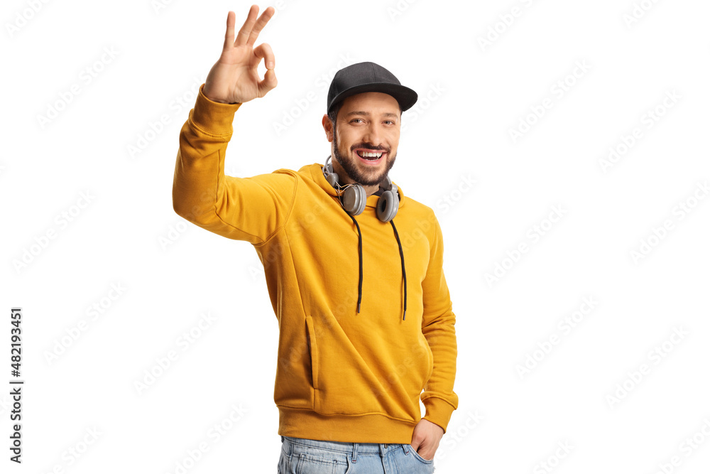 Smiling young man with headphones gesturing ok sign Smiling young man with headphones gesturing ok sign