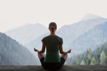 Young woman practicing yoga in mountains at sunset. Harmony, meditation, healthy lifestyle, relaxation, yoga, self care, mindfulness concept