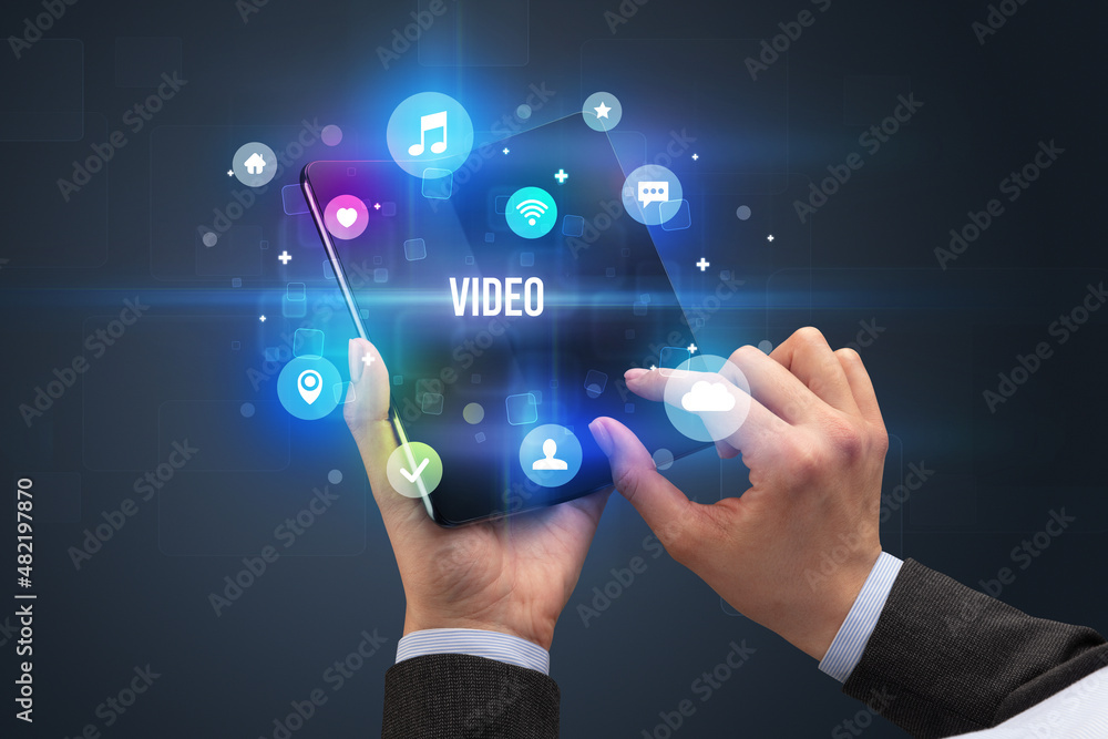 Businessman holding a foldable smartphone Businessman holding a foldable smartphone