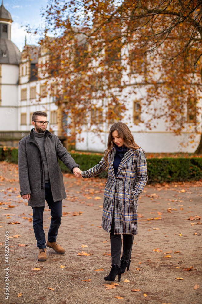 White young european married couple with building behind in autumn