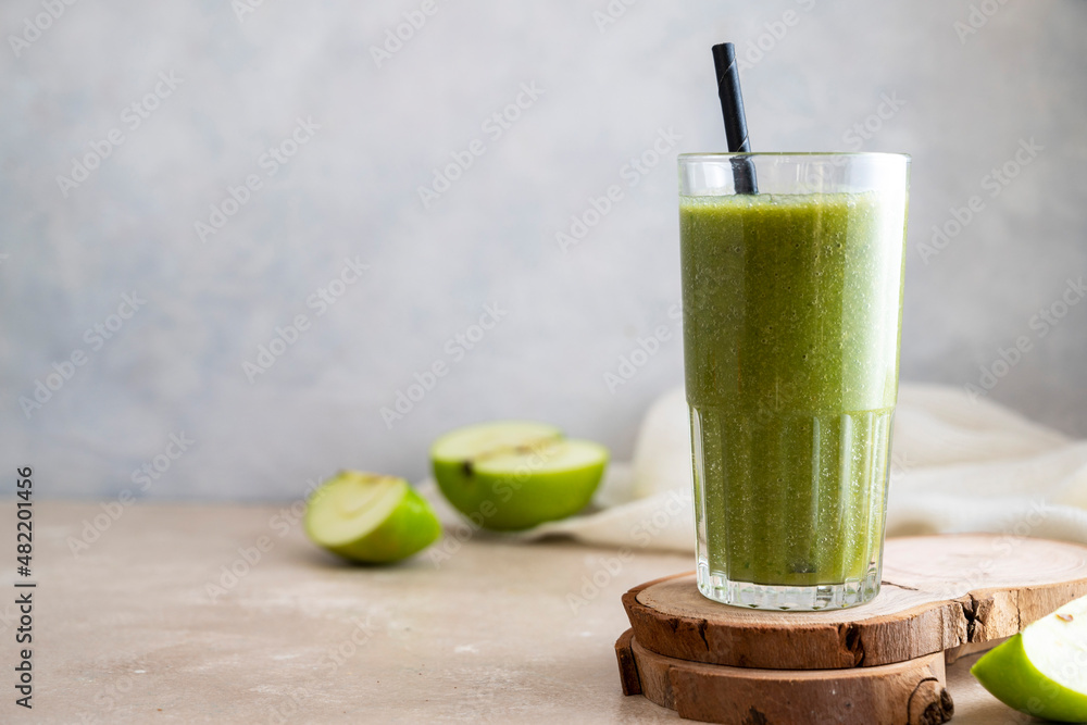 Green apple banana smoothie in glass with paper straw. Healthy lifestyle, dieting and detox. Green apple banana smoothie in glass with paper straw. Healthy lifestyle, dieting and detox.