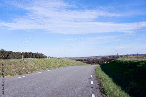 Empty road on the countryside along hills  fields and nature reserve at travel destination in the region of Sk  ne. Photo taken on a summer day at Br  sarps Backar in Sweden.