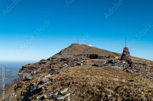 Alto da montanha com alguns rochedos e uma pirâmide de pequenas pedras com uma bandeira a meio do País Basco na montanha de Artzamendi photo
