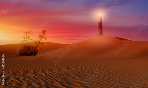 Sailing old ship in desert of sand dune in the background lighthouse 