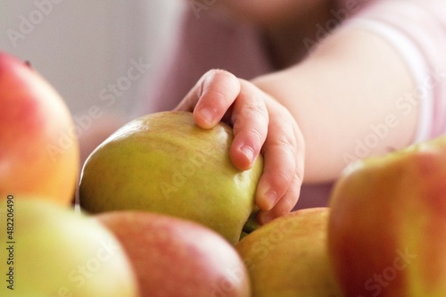 Kinderhand greift nach einem Apfel