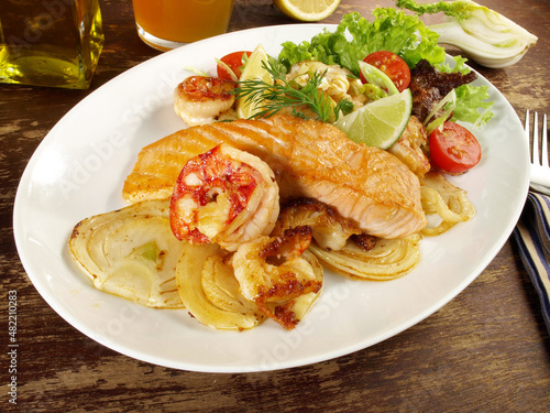 Low Carb Pan Fried Fish Fillet Mix on grilled Vegetables - Roasted Salmon and Prawns on a Plate on wooden Background