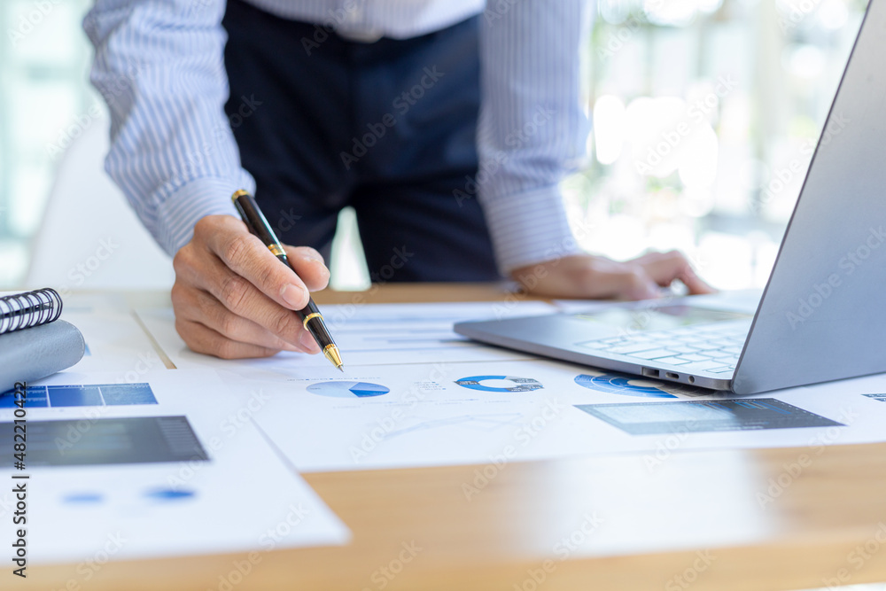 Businessman holding financial documents, he owns a startup company, he sits checking the company's financial summary prepared by the finance department. Management concept of startup company. Businessman holding financial documents, he owns a startup company, he sits checking the company's financial summary prepared by the finance department. Management concept of startup company.