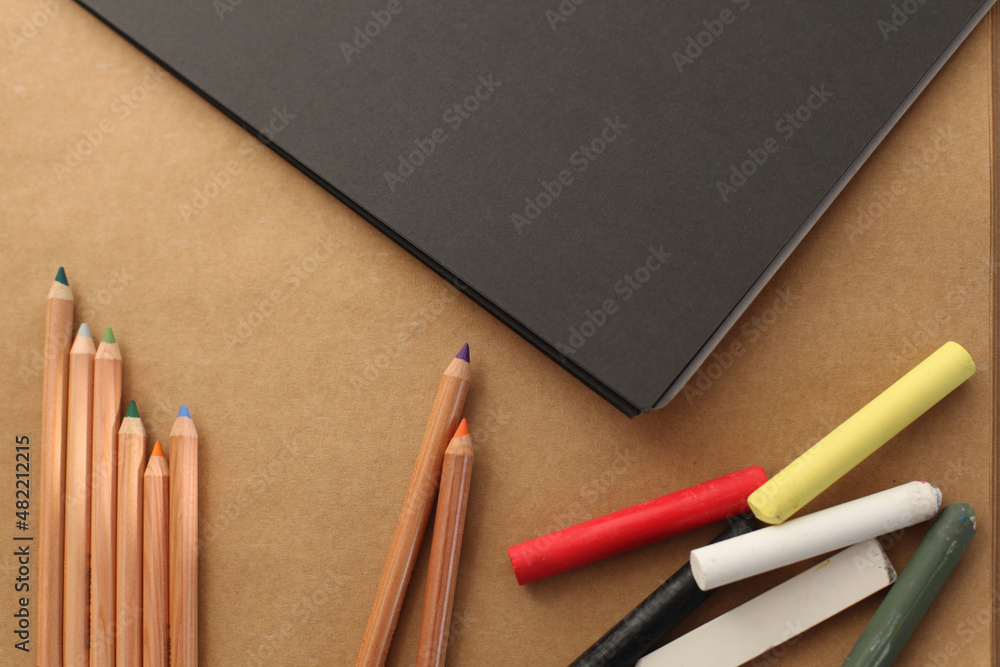 Obraz premium Empty copy space paper canvas and color pencils, pastel chalk. Flat lay, top view.