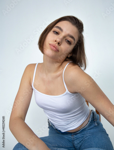 White european woman with bob cut on white in a top and blue jeans